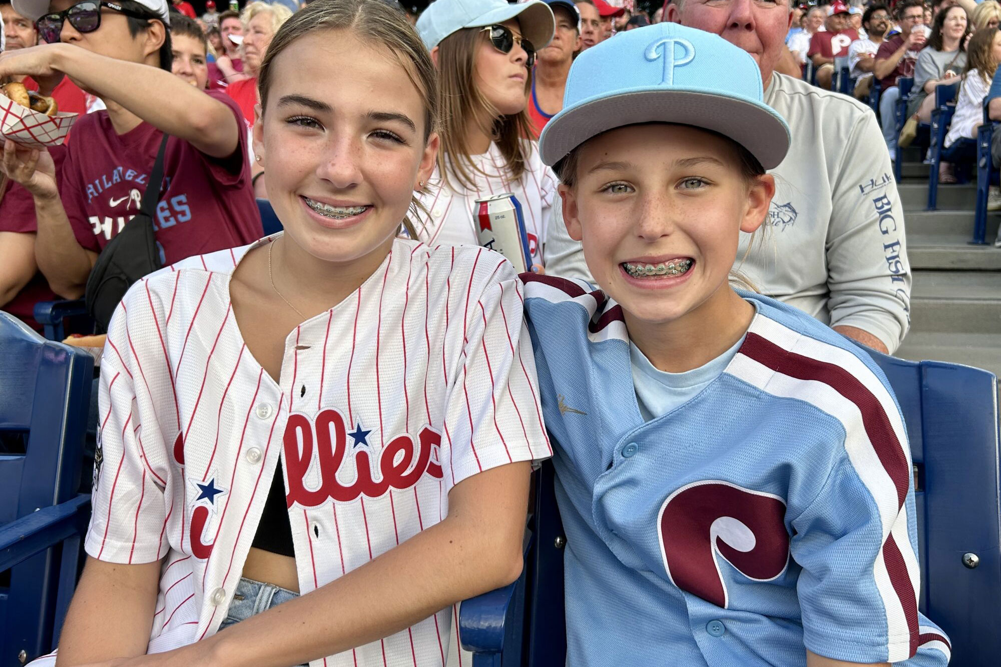 two young patients with braces at baseball game